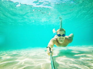 Underwater selfie shot with selfie stick. Deep blue sea. Wide angle shot.