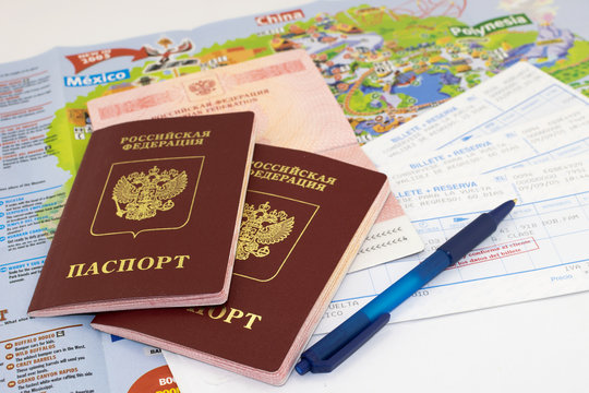 Three russian passports, railway tickets with a pen on the background of a map guide  