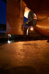 Night view of the propeller and rudder of the ship standing on the dock