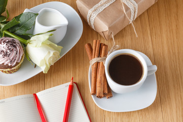 White roses and black coffee on table