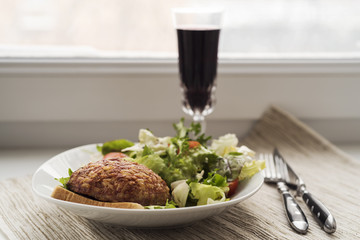 Beef cutlet with salad and wine