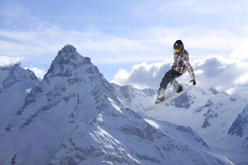 Flying snowboarder on mountains. Extreme sport.
