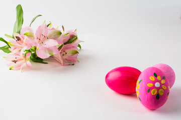 Obraz na płótnie Canvas Pink Easter eggs with floral design and pink flowers on a white background. Easter background. Easter background. Easter symbol. Copy space