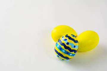 Yellow hand- decorated Easter eggs with abstract design on a white background. Easter background. Easter symbol. Copy space