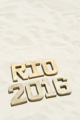 Golden Rio 2016 sign sitting on sand beach background in Rio de Janeiro Brazil