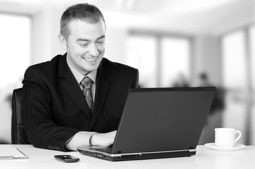 Young happy business man working on notebook