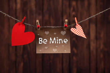 Red hearts and blank note, on wooden background