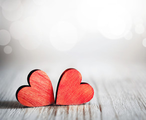 Valentines day background with two red hearts on wooden background