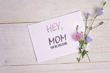 Naklejka premium Hey, Mom , Your are awesome message card and bouquet of flowers on rustic wooden table. Funny valentine card for mother, birthday card, funny mother's day card