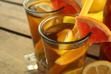 Iced tea with lemon and grapefruit on wooden background