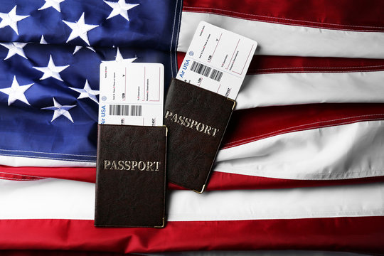 Passports, tickets lying on American Flag background