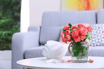 Beautiful rose in vase on table in room