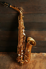 Beautiful golden saxophone on wooden background