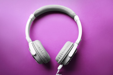 White and grey headphones on purple background