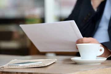Businessman having lunch and working in a cafe, close-up