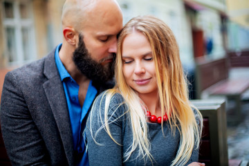Young couple in love, hugging on the street. Selective focus. bald guy with a beard