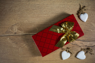 Present box with golden ribbon and small white hearts