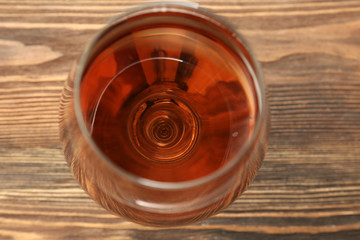 Glass of wine on wooden table. Top view