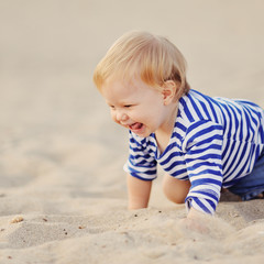 Маленькая девочка играет в песке на пляже