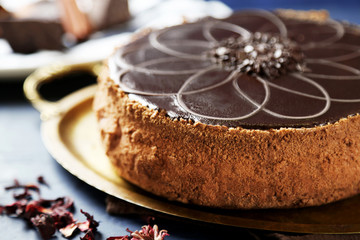 Tasty chocolate cake on tray, on color wooden background