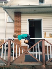 Little boy play laying in front of a house. country style