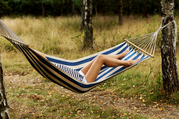 Young blonde woman resting on hammock