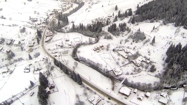 Aerial shot of snow-covered road in the countryside Carpathian Mountains