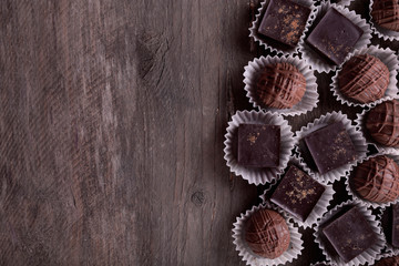 Assorted chocolate candies on wooden background