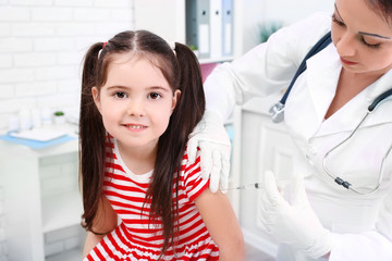 Doctor giving a child injection in the office