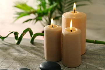 Spa composition of candles, stones and bamboo on light background