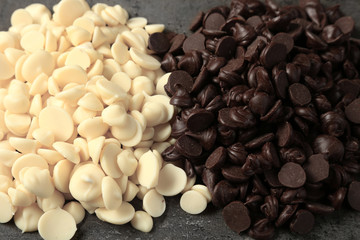 Dark and white chocolate morsels on gray background