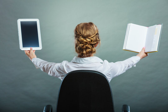 Woman holding traditional book and e-book reader