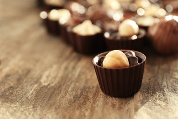 Chocolate candies on wooden background, close up