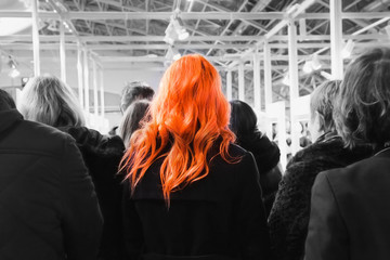  girl with red hair in a grey crowd