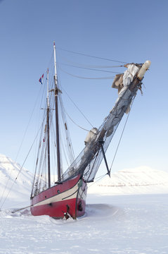 Sailboat stranded on sea ice - Vertical