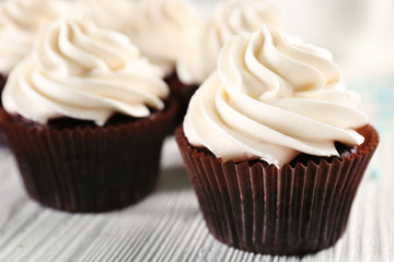 White cupcakes on wooden table