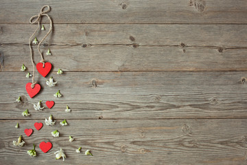 Wooden background with red hearts and flowers