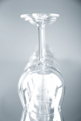 Wine glasses in a row upside down on light grey background