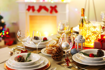 Christmas table setting with holiday decorations on fireplace background