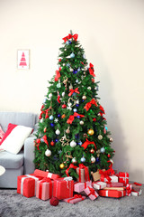 Christmas fir tree with gifts in living room