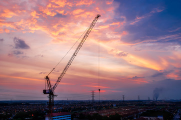 Fototapeta na wymiar Hoisting tower crane with sunset cloud background