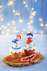 Christmas cupcakes with candies on wooden stand, closeup
