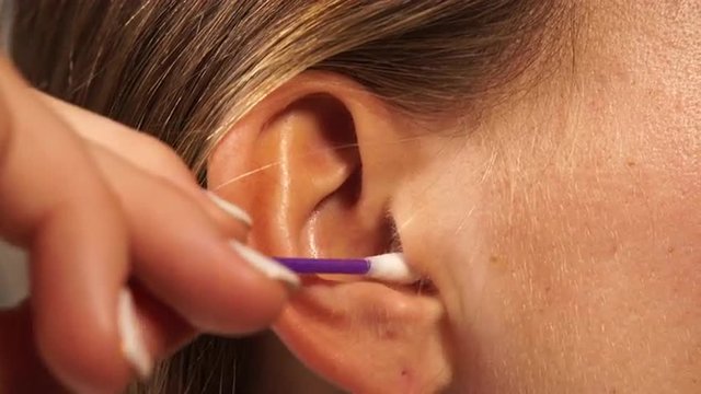 Woman cleaning ear with cotton swabs closeup 4K