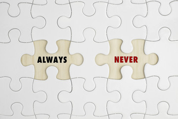 Jigsaw puzzle on wood background with a word ALWAYS and NEVER