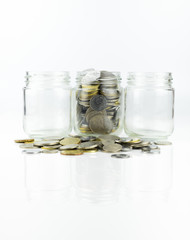 Glass jar with full of coins & 2 empty jar over white background