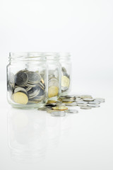 Jar with coins. Selective focus over white background