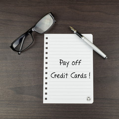 The words Pay off credit cards written on a notepad