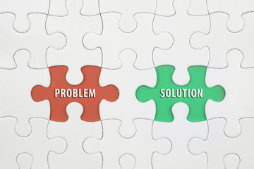 Jigsaw puzzle on color paper background with a word PROBLEM and SOLUTION