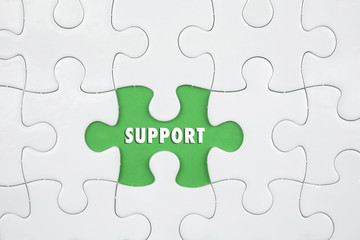 Fototapeta premium Jigsaw puzzle on color paper background with a word SUPPORT