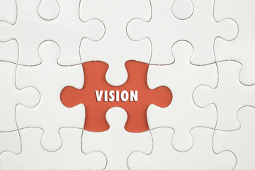 Fototapeta premium Jigsaw puzzle on color paper background with a word VISION